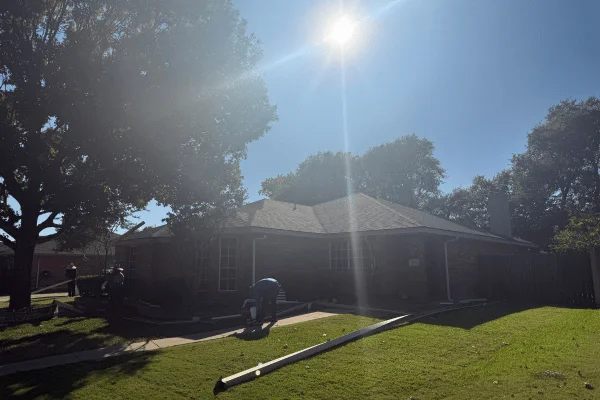 Roof installation with gutters staged on the ground in DFW